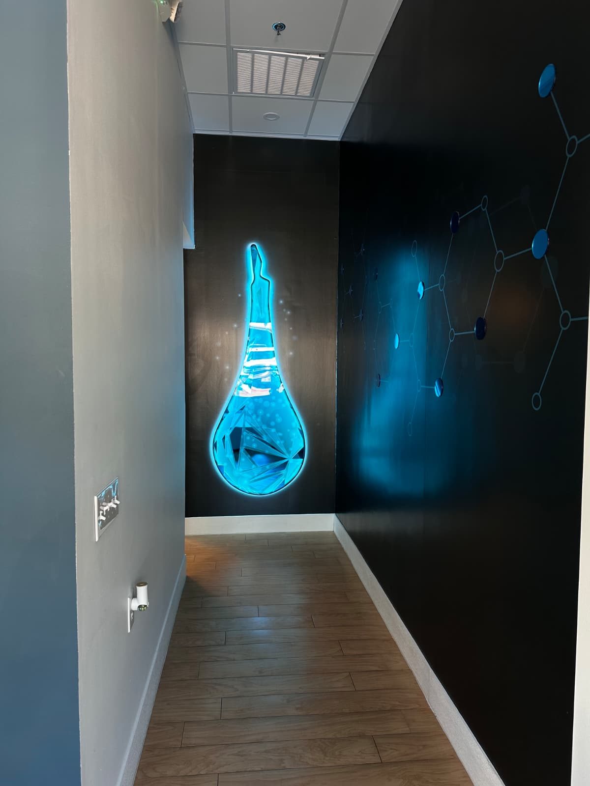 Illuminated drip artwork inside The DRIPBaR Frisco